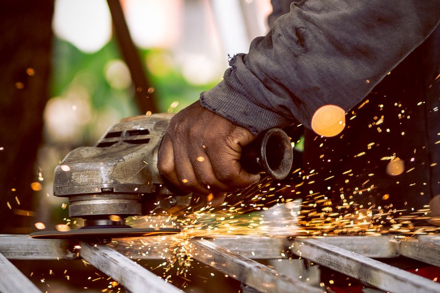 Grinding wheel work — worker grinding metal